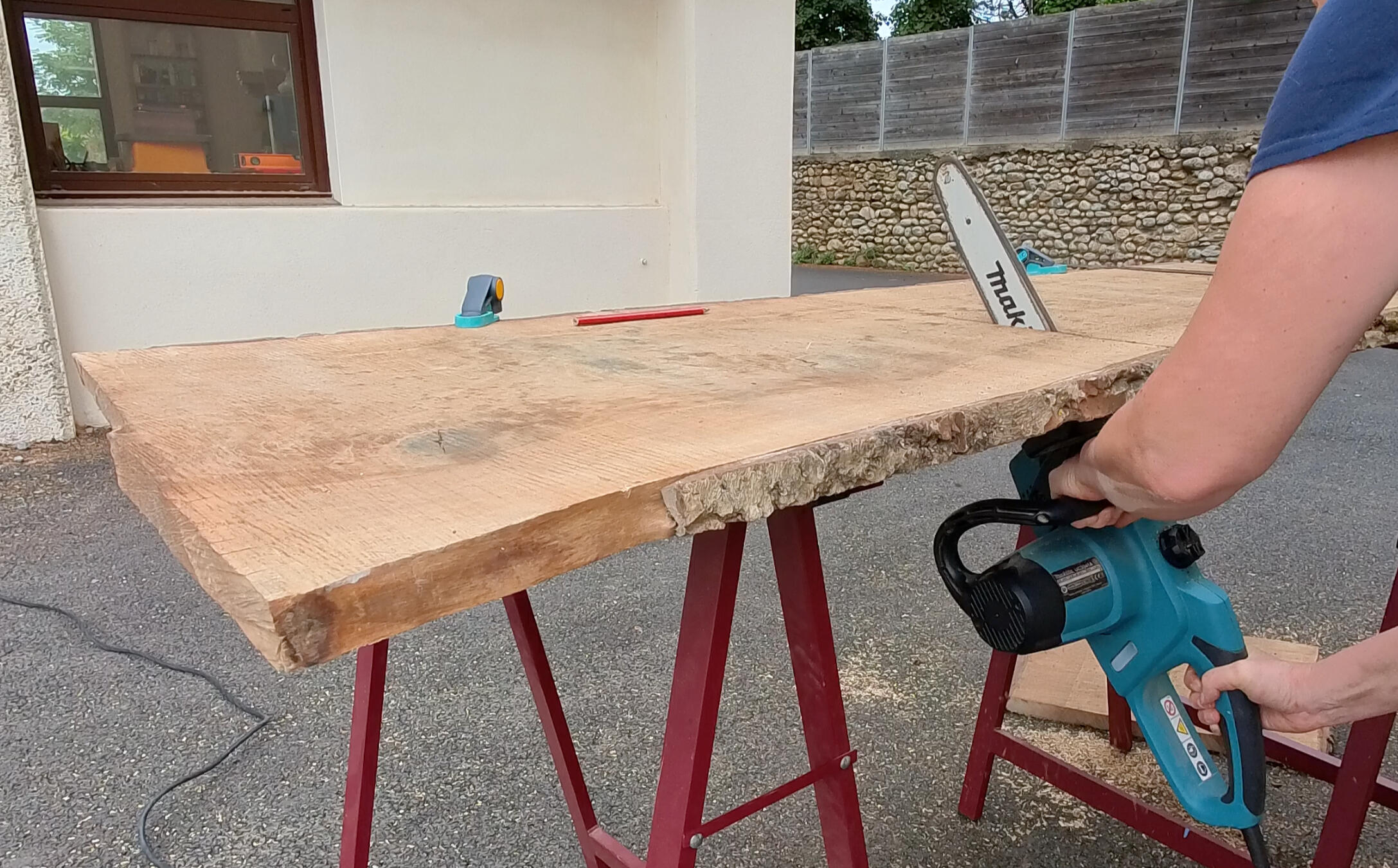 Découpe d'un plateau de bois à la tronçonneuse
